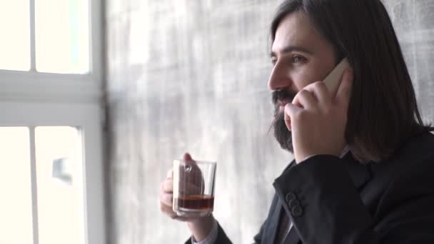 Jonge man dragen pak praten op een mobiele telefoon in de ochtend op een venster met kopie ruimte, — Stockvideo
