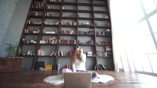 Dívka sedící na flooor a poslouchat hudbu s notebookem — Stock video