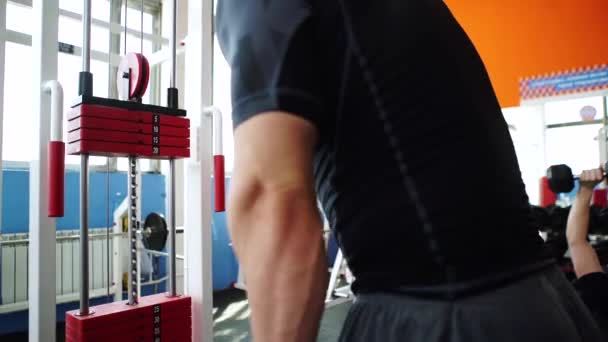 Hombre guapo en el gimnasio haciendo ejercicios — Vídeos de Stock