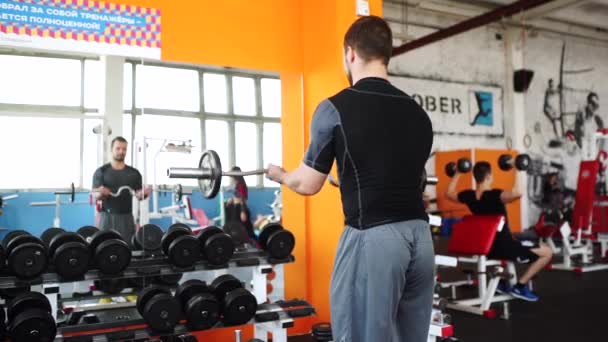 Hombre guapo en el gimnasio haciendo ejercicios — Vídeos de Stock