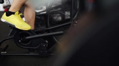 Yan görünümü spor ayakkabı spor salonunda Bisiklete binme genç adam yakın çekim bölümü. kaymak vurdu