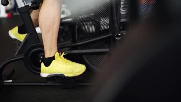 Vista lateral close-up parte do jovem em sapatos esportivos de ciclismo no ginásio. tiro deslizante — Vídeo de Stock