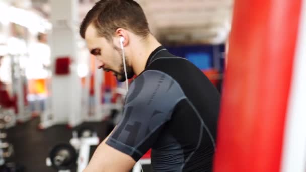 Bodybuilder formation dans une salle de gym et utiliser son téléphone portable — Video