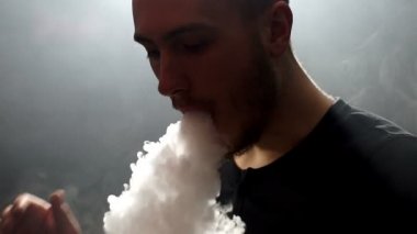 duman e-sigara vape slowmotion olarak ile büyük bulutlar exhaling genç vaper adam