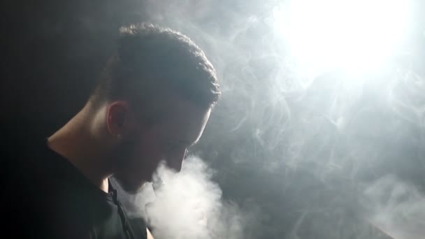 Joven vaper hombre exhalando grandes nubes de humo con vapor de cigarrillo electrónico en cámara lenta — Vídeo de stock