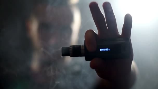Giovane uomo più vago che esala grandi nuvole di fumo con vaporizzatore di sigaretta elettronica al rallentatore — Video Stock