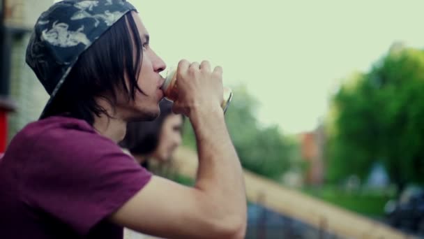 Jovem longboardista bebe água mineral na cidade — Vídeo de Stock
