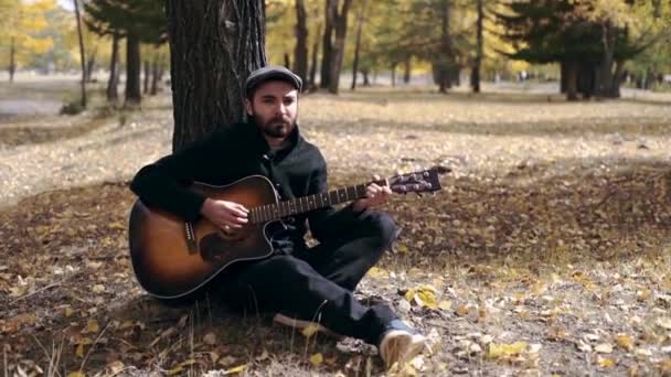 ひげの男は森でギターを弾く — ストック動画