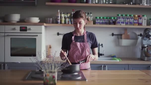 Niña en delantal preparando comida en la cocina — Vídeos de Stock