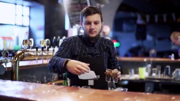 Camarero joven preparando coctel con coctelera — Vídeo de stock