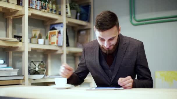 Casual hombre de negocios leyendo en la tableta de la PC en el café — Vídeos de Stock
