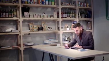 iş adamı akıllı telefon kullanıyor ve e-sigara ile kafede dergi okumak