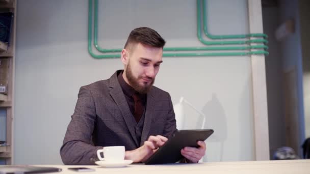 Casual hombre de negocios leyendo en la tableta de la PC en el café — Vídeos de Stock