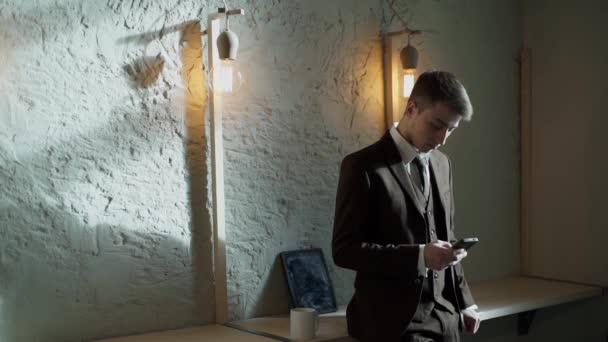 Joven hombre de negocios usando teléfono inteligente en la cafetería — Vídeo de stock