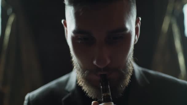 Närbild av en skäggig man i kostym röka elektronisk cigarett — Stockvideo