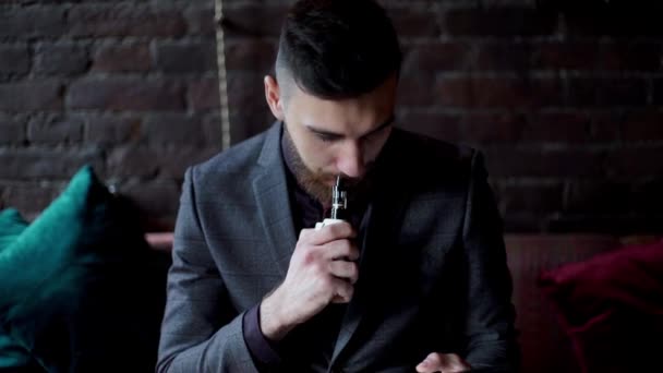 Сучасний хіпстерський бізнесмен п'є каву в кафе і працює на планшеті куріння електронних сигарет вейп — стокове відео