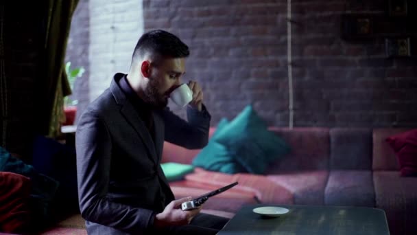 Moderna hipster affärsman dricka kaffe i cafeand arbetar på tablet rökning e-cigarett vape — Stockvideo
