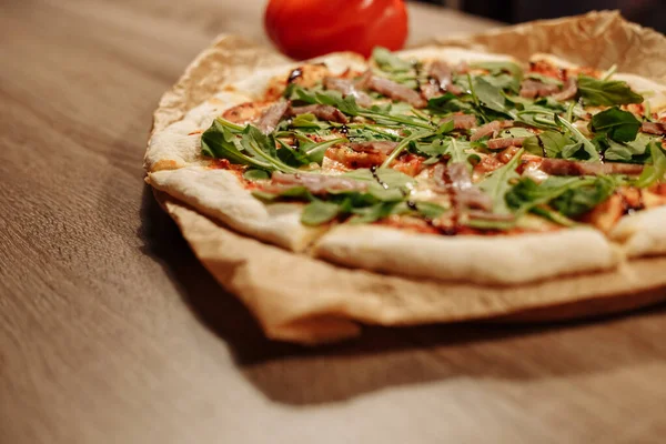 Świeża Pizza Ziołami Tuńczykiem Sosem Balsamicznym Papierze Spożywczym Drewnianym Stole — Zdjęcie stockowe