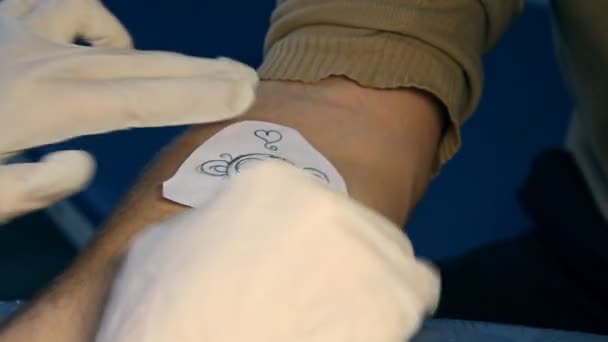Att göra en tatuering på en mans hand — Stockvideo