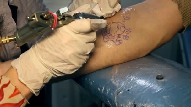 Maken van een tatoeage op een mans hand — Stockvideo