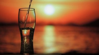 Maden suyu günbatımı arka plan üzerine dökülür.