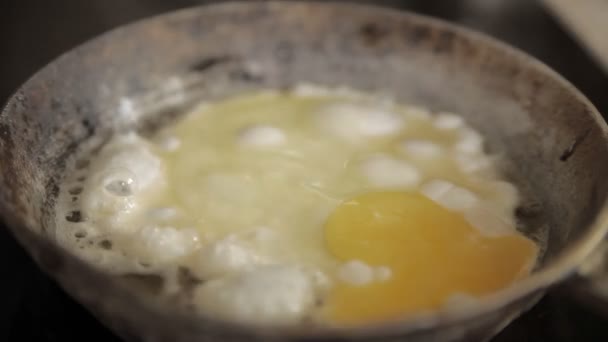 Scrambled eggs fried in an old frying pan — Stock Video