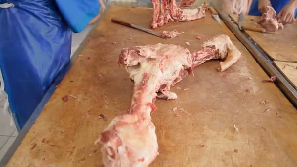 Los carniceros están cortando cadáveres de animales en la mesa — Vídeo de stock