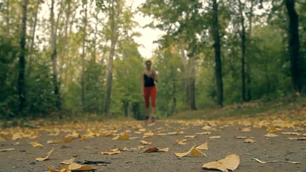 Une femme allume la musique dans son téléphone et commence sa course matinale .