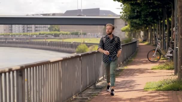 Hipster toeristische loopt langs Europese embankment. — Stockvideo