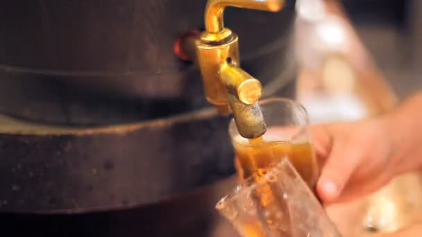 Um barman está a servir uma cerveja escura. — Vídeo de Stock