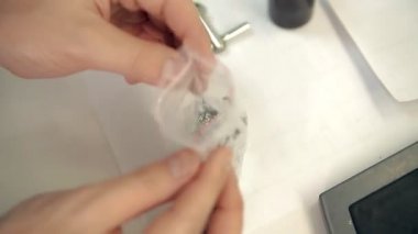 Laboratorian pullu bir paket üzerinden alıyor.