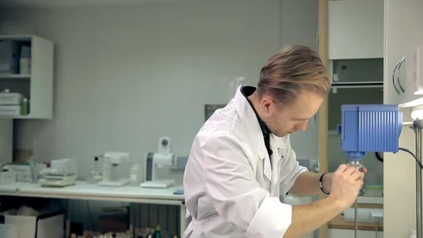 Der Laborant bereitet die Maschine vor, um die Mittel der Körperhygiene zu überprüfen — Stockvideo