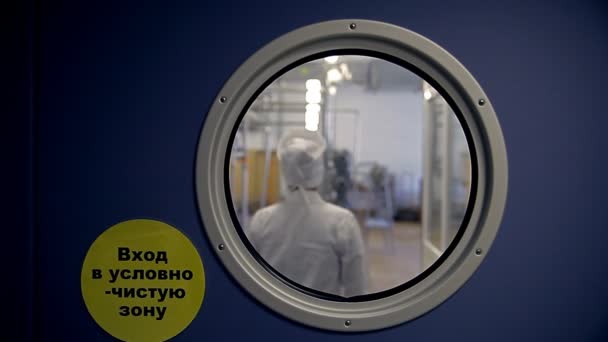 En kvinna i en labbrock kommer in i en hemlig rysk laboratorium. — Stockvideo