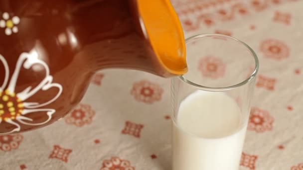 Melk in een glas van een kruik gieten — Stockvideo