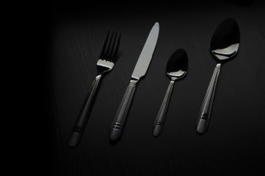 siyah bir masada çatal bıçak takımı