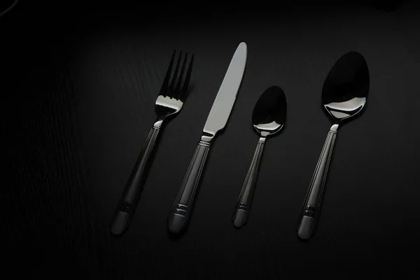 Cutlery on a black table — Stock Photo, Image