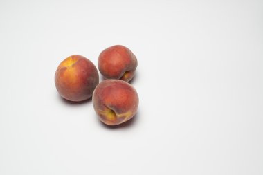 beyaz zemin üzerinde üç şeftali