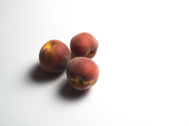 beyaz zemin üzerinde üç şeftali