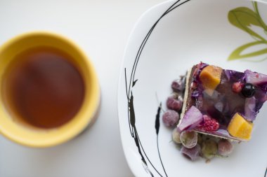 beyaz bir masada meyve kek ve çay