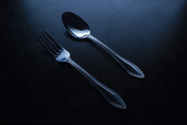 叉子和勺子上一个黑色的桌子 — 图库照片