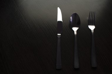 siyah bir masada çatal bıçak takımı