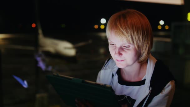 Mulher bonita gosta do tablet no aeroporto — Vídeo de Stock