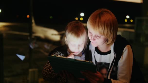 Madre e hija 5-6 años jugando en la tableta en el aeropuerto — Vídeo de stock