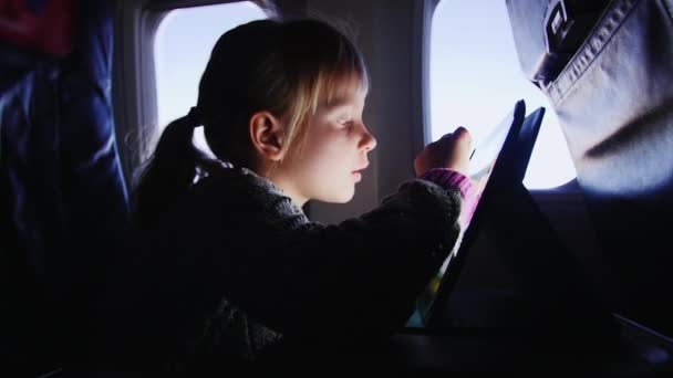 Una chica disfruta de la tableta en el avión — Vídeos de Stock