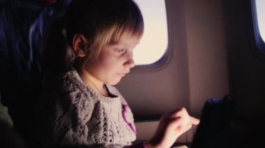 uçak tablete ile oynarken küçük kız