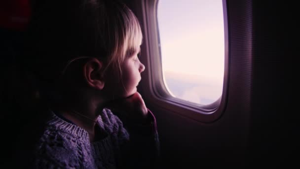 Menina olhando pela janela no avião — Vídeo de Stock