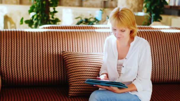 Attractive female tourist communicate with loved ones through the tablet — Stock Video