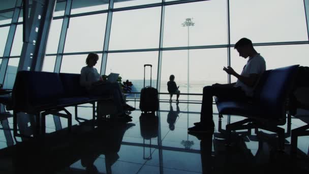 Waiting for the flight - a woman with two children in airport terminal — Stock Video