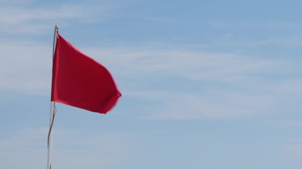 Bandeira vermelha em um fundo de céu azul — Vídeo de Stock