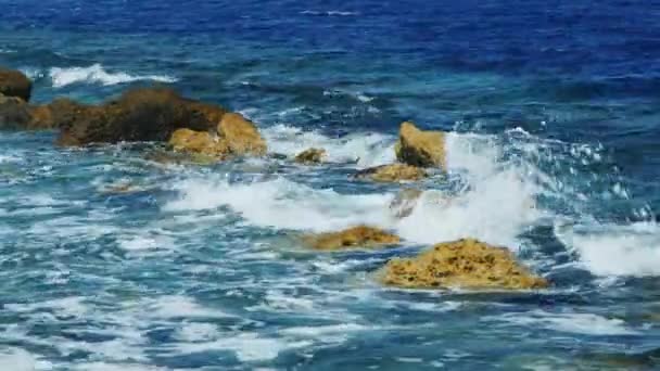 Onde che si infrangono sulle rocce in una giornata di sole — Video Stock